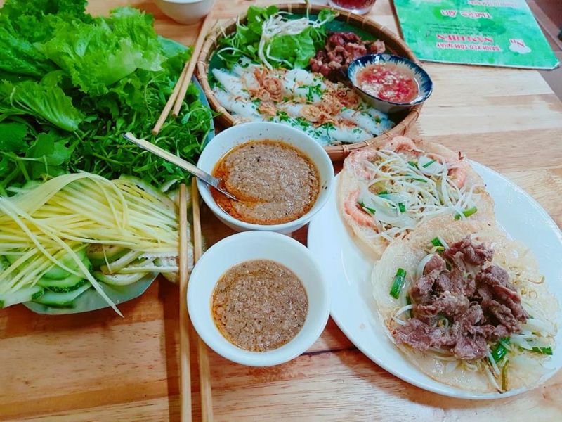 Bàn ăn với bánh hỏi thịt nướng và bánh xèo tôm nhảy, bánh xèo thịt bò