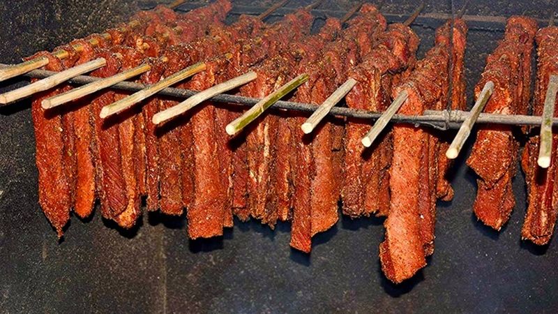 Công đoạn thịt trâu được mắc, treo trên giàn bếp